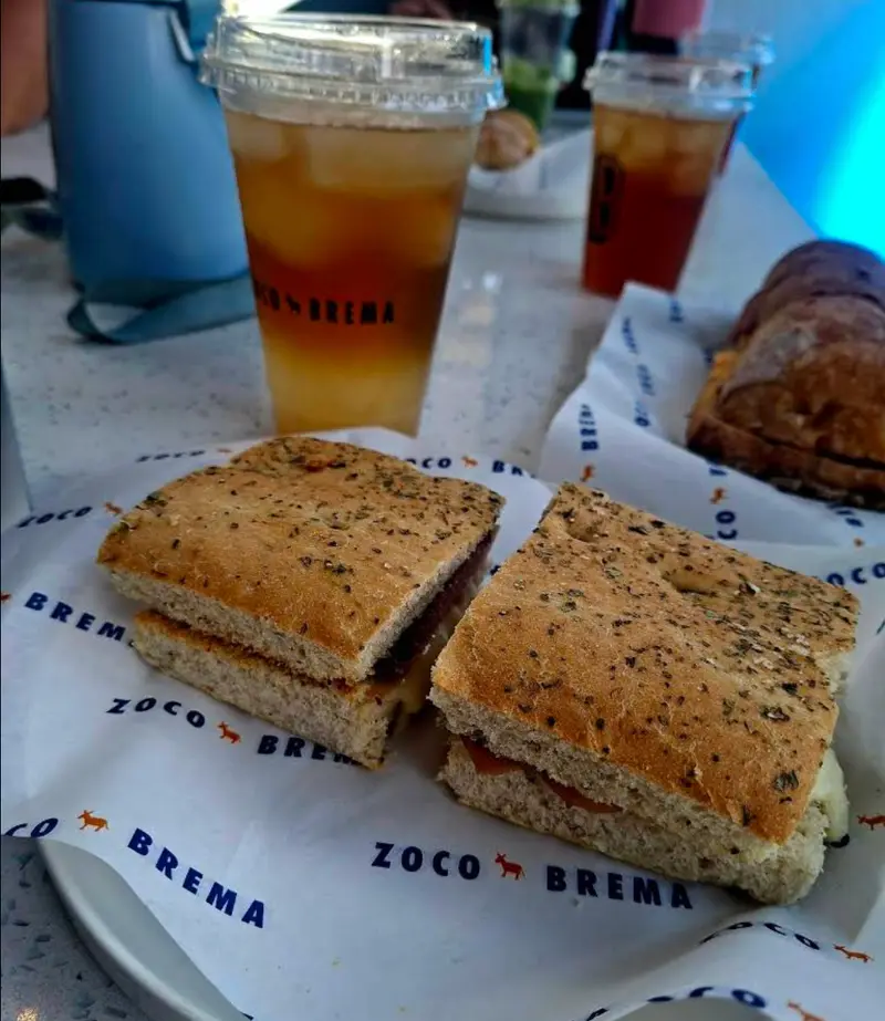Sándwich en focaccia sobre el papel de envoltura con burros naranjas