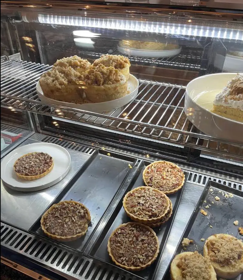 Vitrina de la barra con pays de nuez, crumbles y postres del día